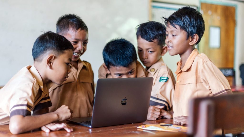 Kids looking at a laptop Internet