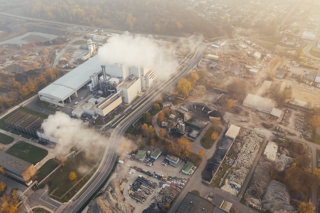 data Aerial view of a factory with a lot of smoke coming out
