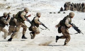 5 military people running across sand dunes Armed Conflict UCDP