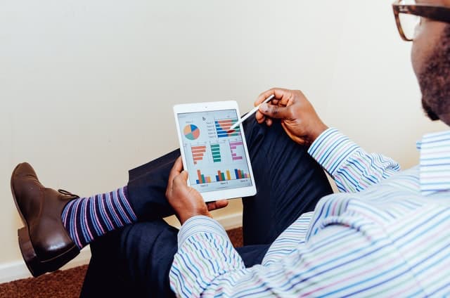 Men holding tablet showing charts social